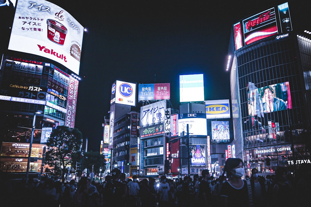 a crowd of people walking in a city at night