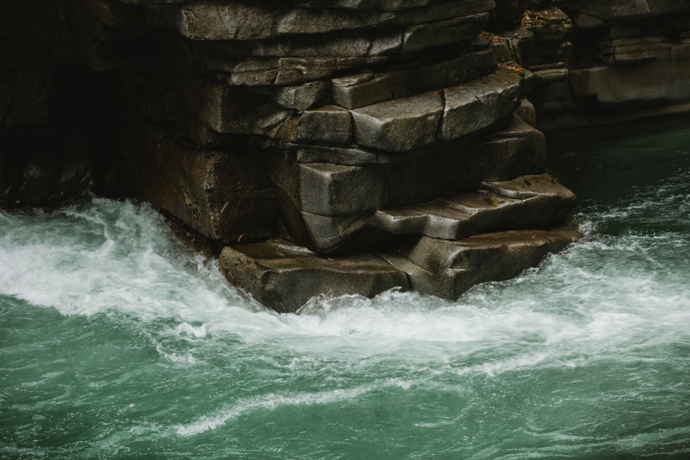 Una ola rompiendo contra una pared de roca