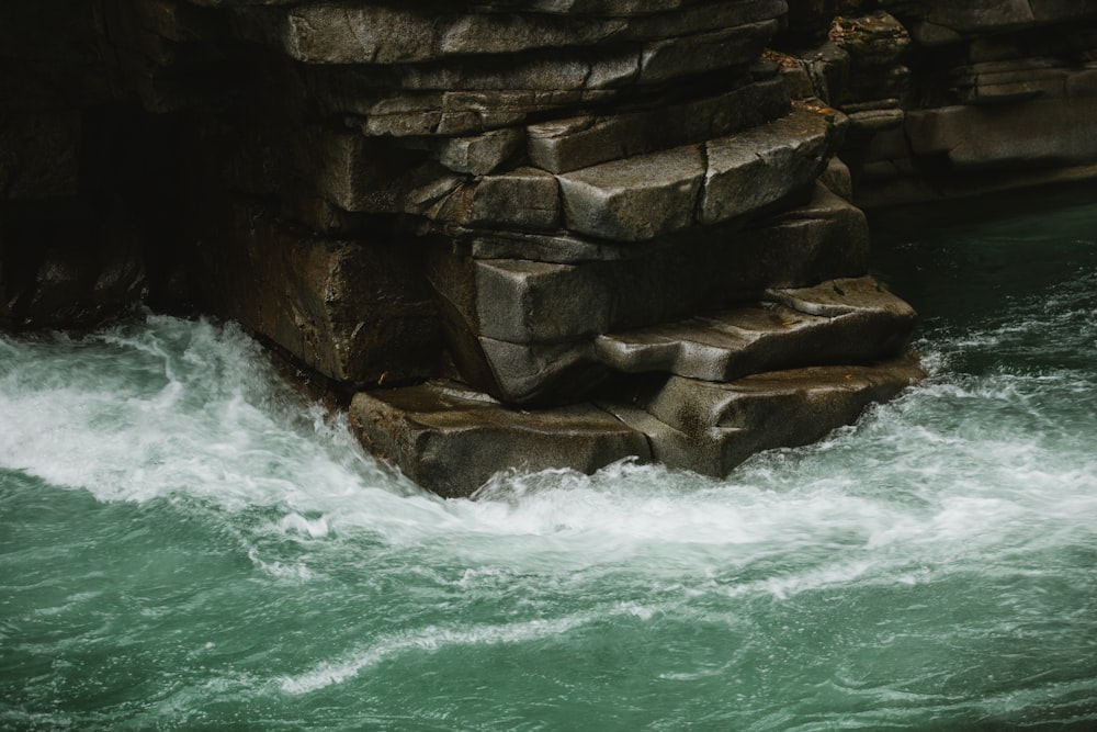 a wave crashing against a rock wall