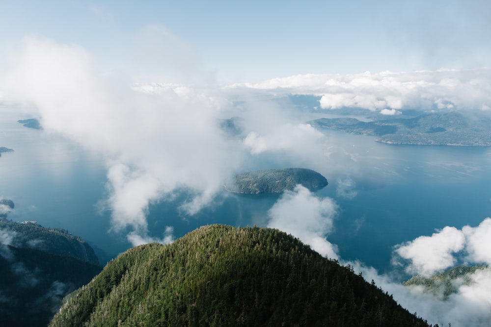 a grassy hill with clouds above it