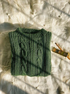 A cozy blue knit sweater folded neatly on a rustic wooden table.