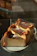 Close-up of a homemade caramel cake slice on a rustic plate with soft natural light.