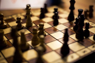 A chess creator smiling while explaining tactics in front of a camera with soft neutral background.