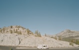A scenic view of mountains with a Range Rover in motion.