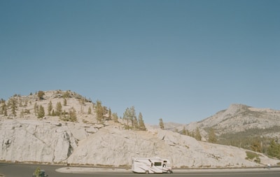 A scenic view of mountains with a Range Rover in motion.