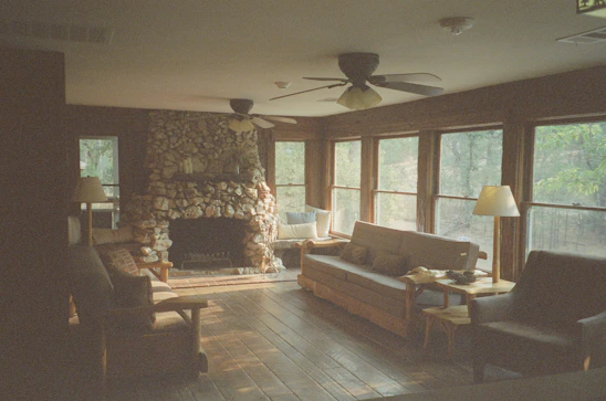 A warm, inviting living room extended with natural wood accents and large windows letting in sunlight.