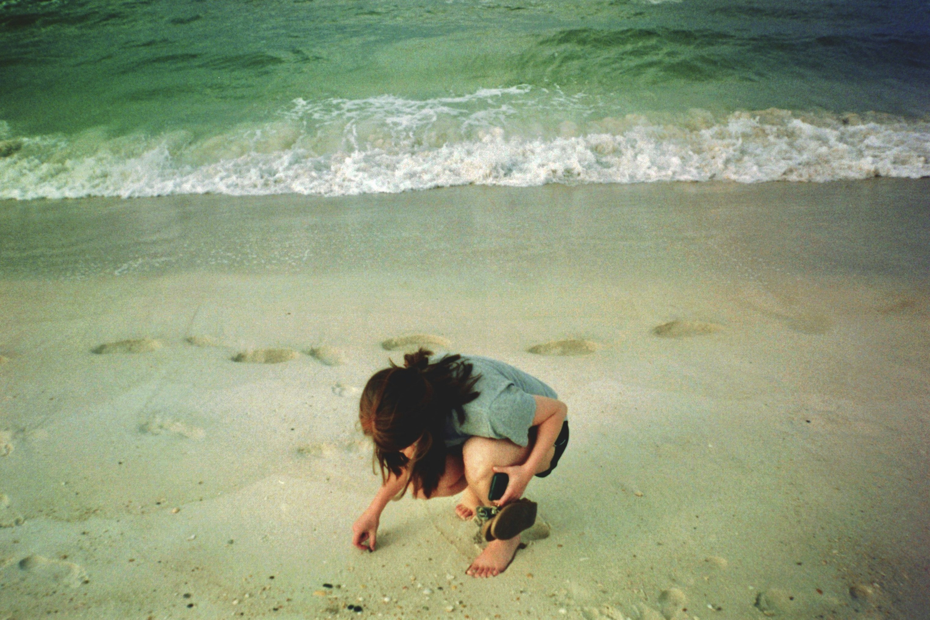 a person bending over on a beach
