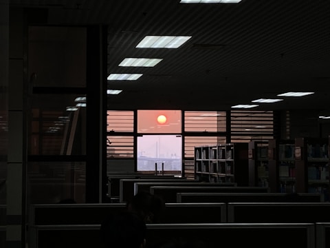 A sunset view through office windows, symbolizing dedication and long hours.
