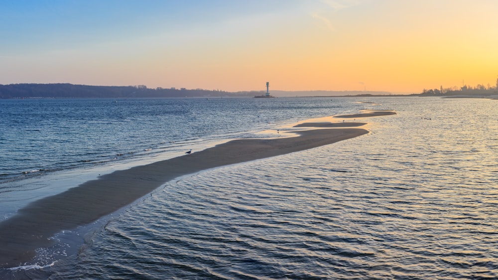 a beach with a boat in the distance