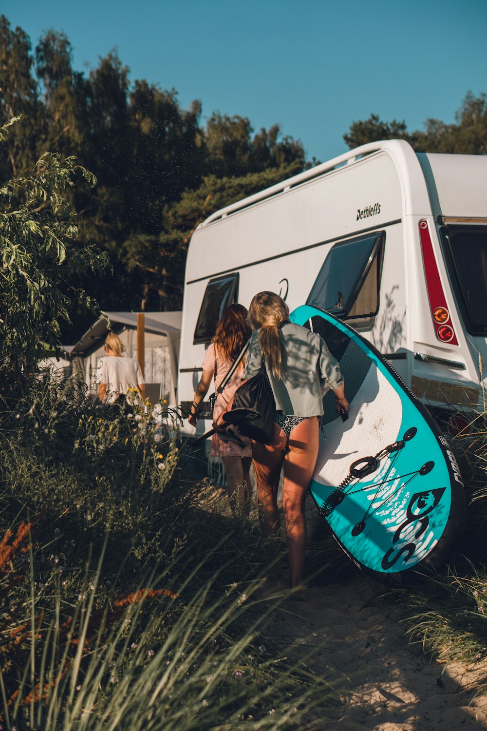 two women standing next to a van