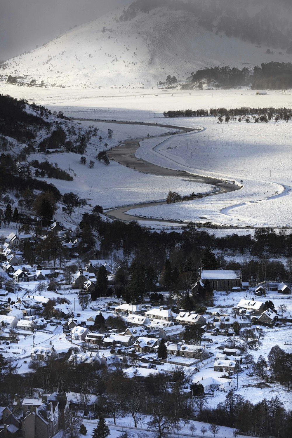 a snowy landscape with buildings and trees