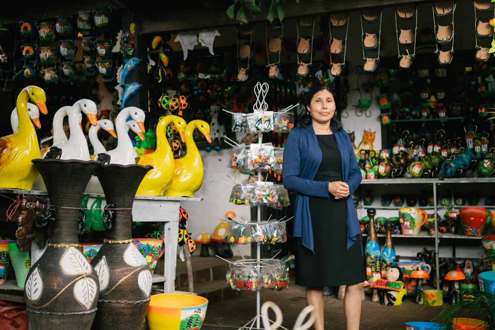 a person standing in front of a store with many vases and vases