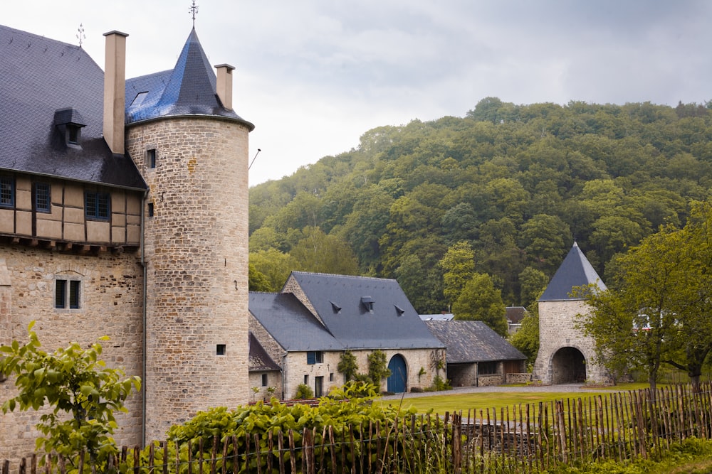 a stone building with a tower and a fence in front of it