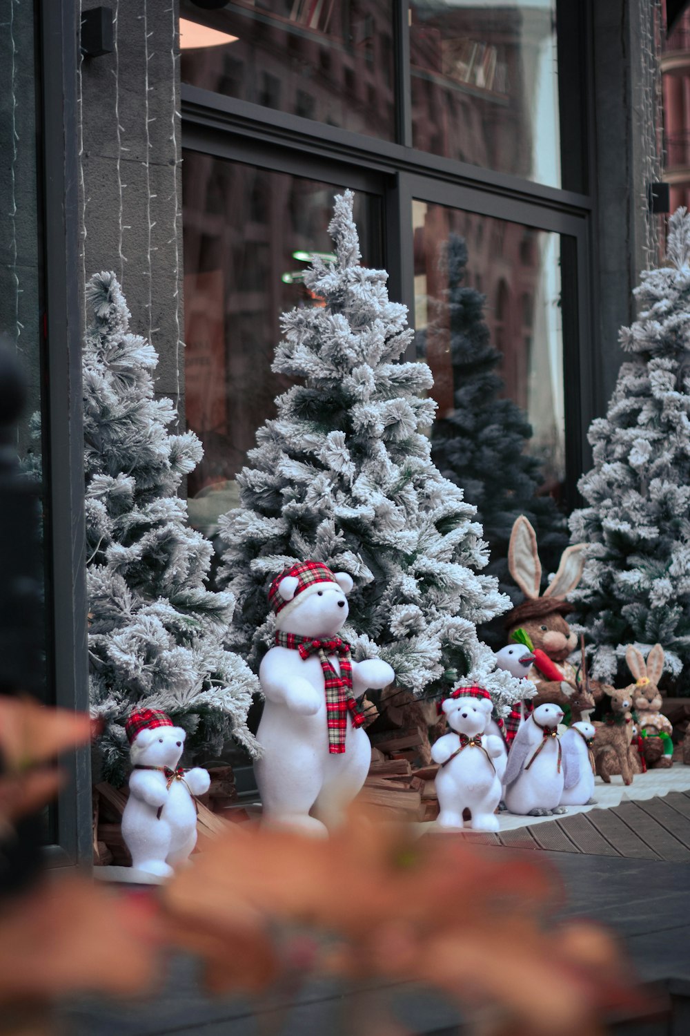 Un muñeco de nieve junto a un árbol de Navidad