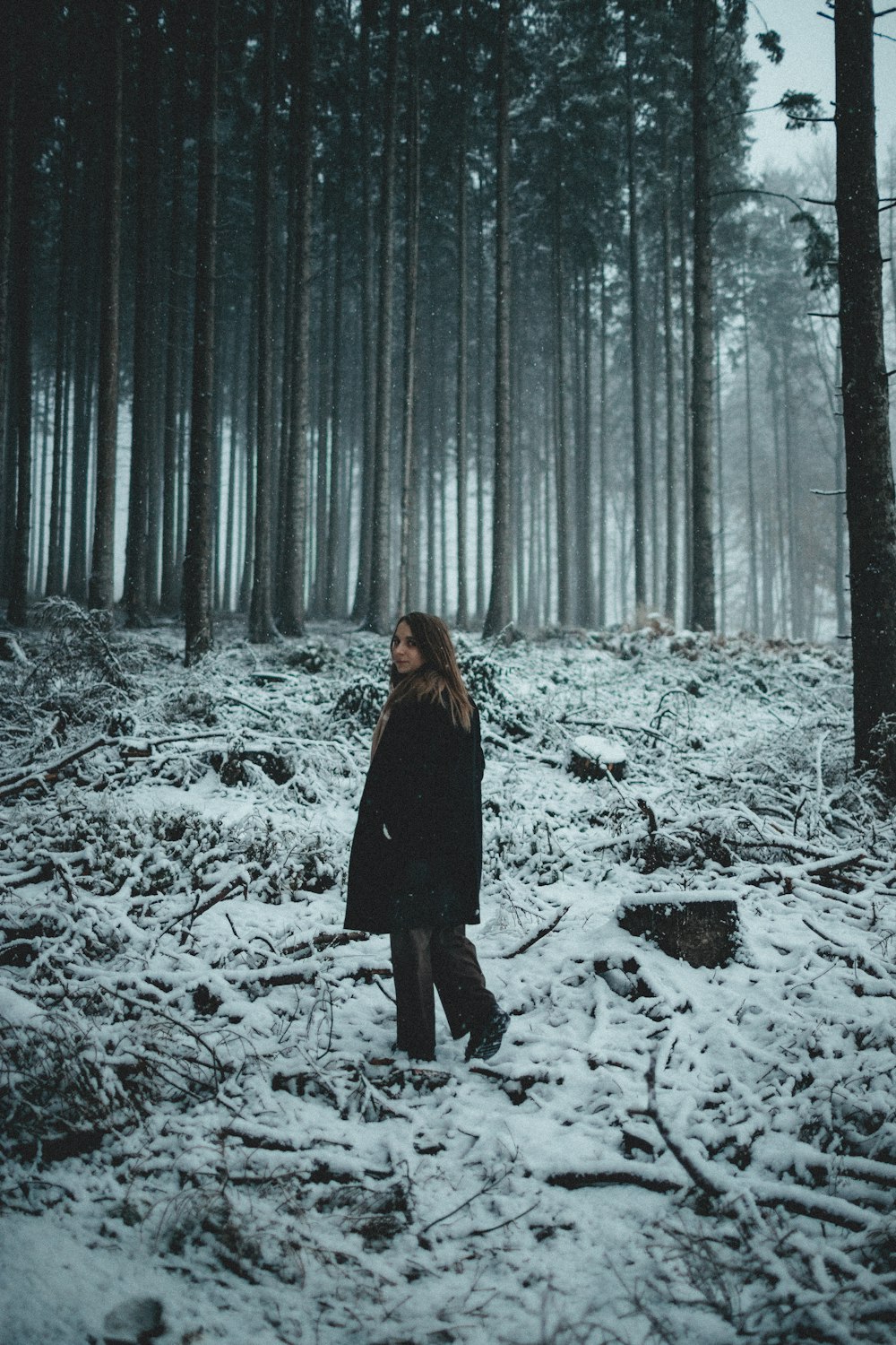 a person standing in a snowy forest