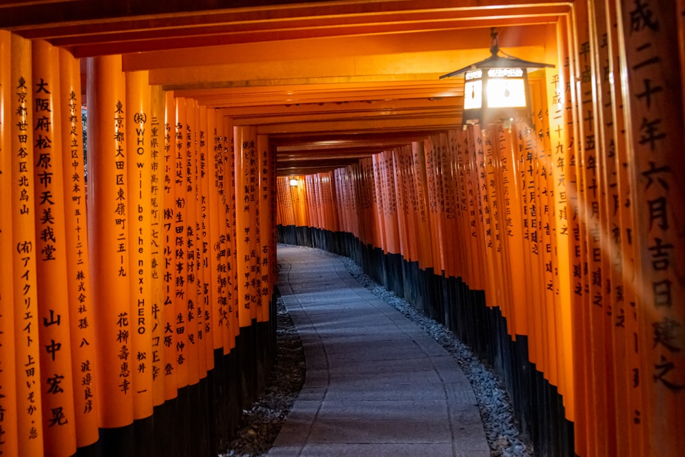 a long hallway with gold curtains with Fushimi Inari-taisha in the background