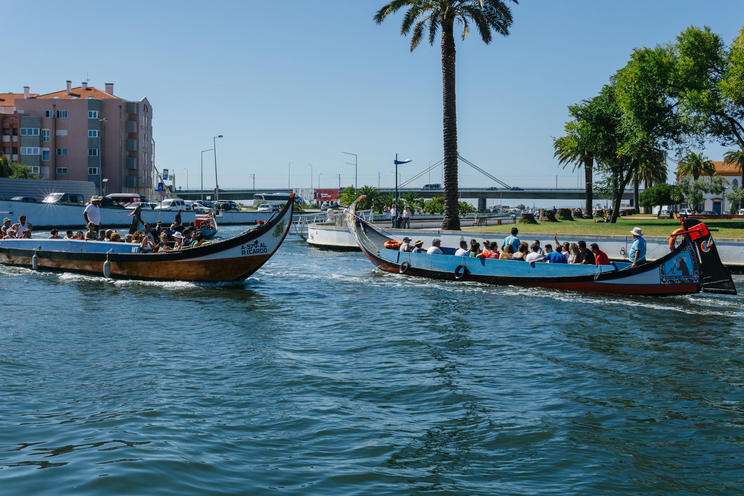 Een gracht in Aveiro met kleurig beschilderde moliceiro-boten en art-nouveaugevels langs de kade
