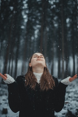 a woman with her arms out in the snow