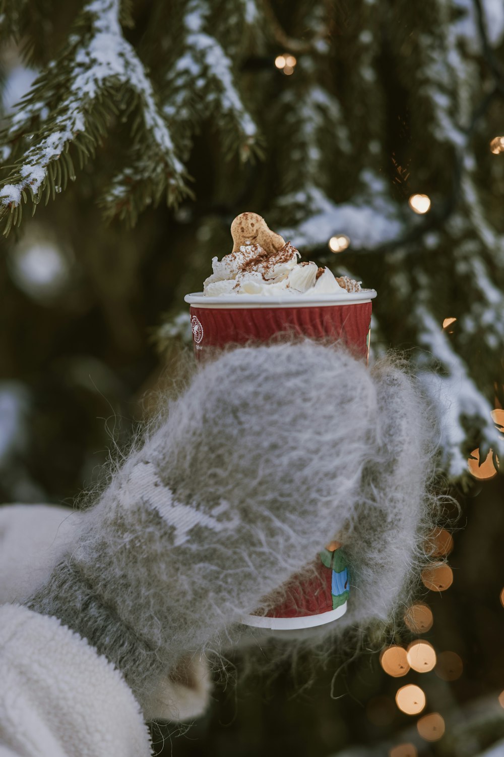 a snowman with a small christmas tree in the background