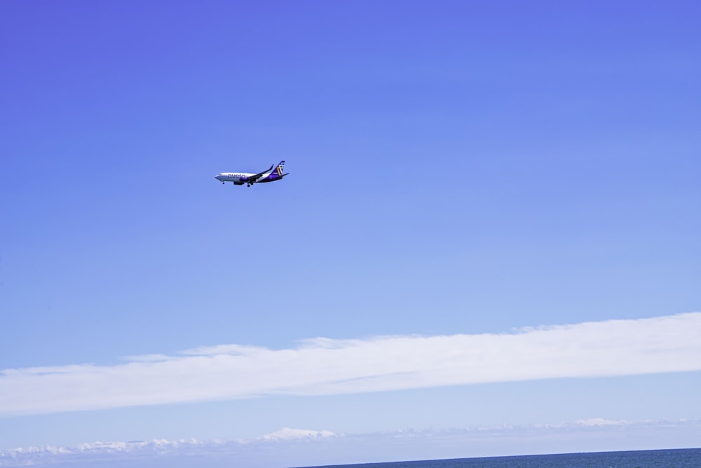 um avião voando sobre o oceano em um dia claro