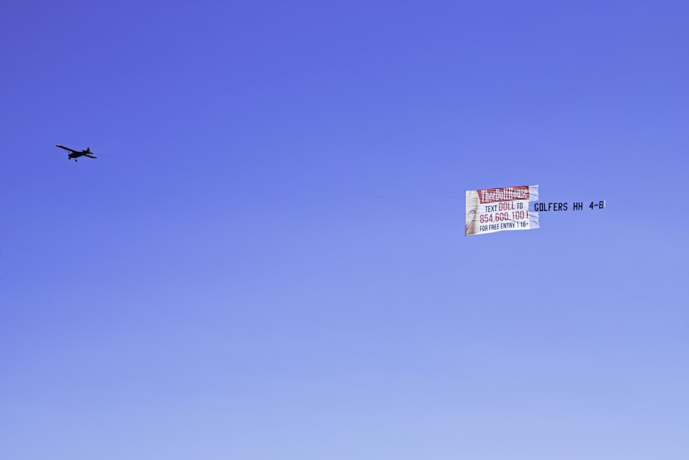 um avião voando no céu com uma bandeira presa a ele