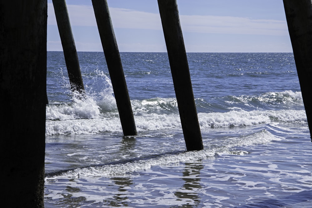 a view of the ocean from under a pier