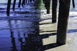 Soft waves gently lapping against a wooden pier at dusk.
