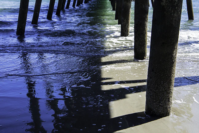 Soft waves gently lapping against a wooden pier at dusk.