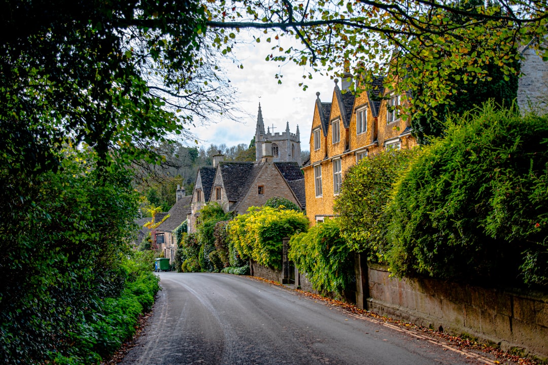 View down the street to the church in Castle Combe Village in the Cotswolds, Wiltshire, UK - Photo by George Ciobra | Castle Combe England
