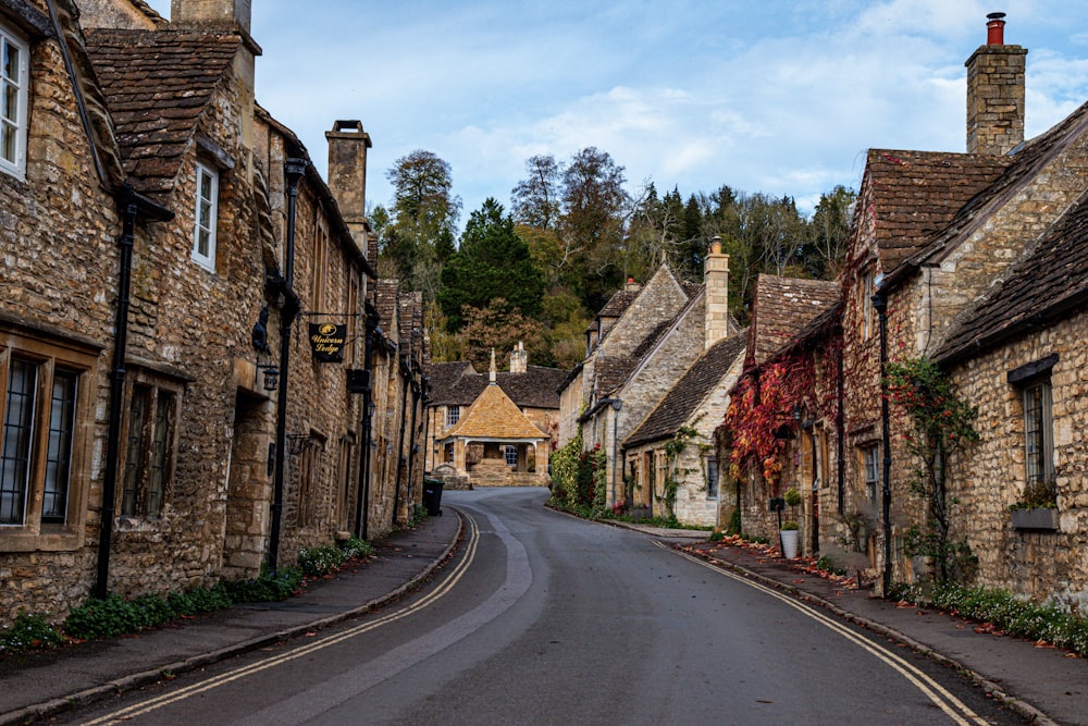 a street lined with stone buildings next to a forest