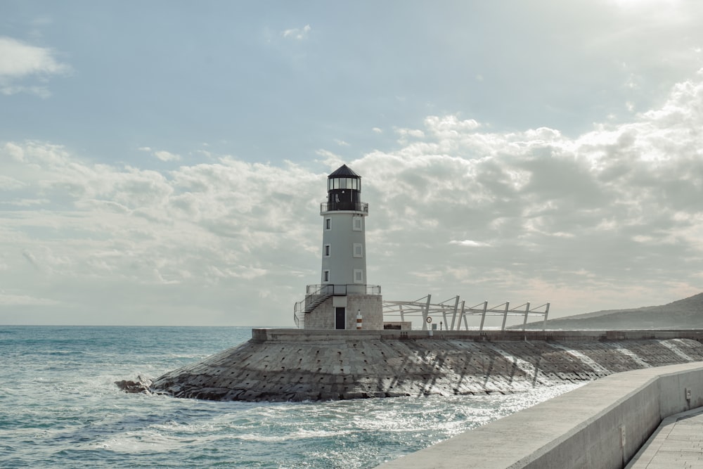 a light house sitting on top of a pier next to the ocean