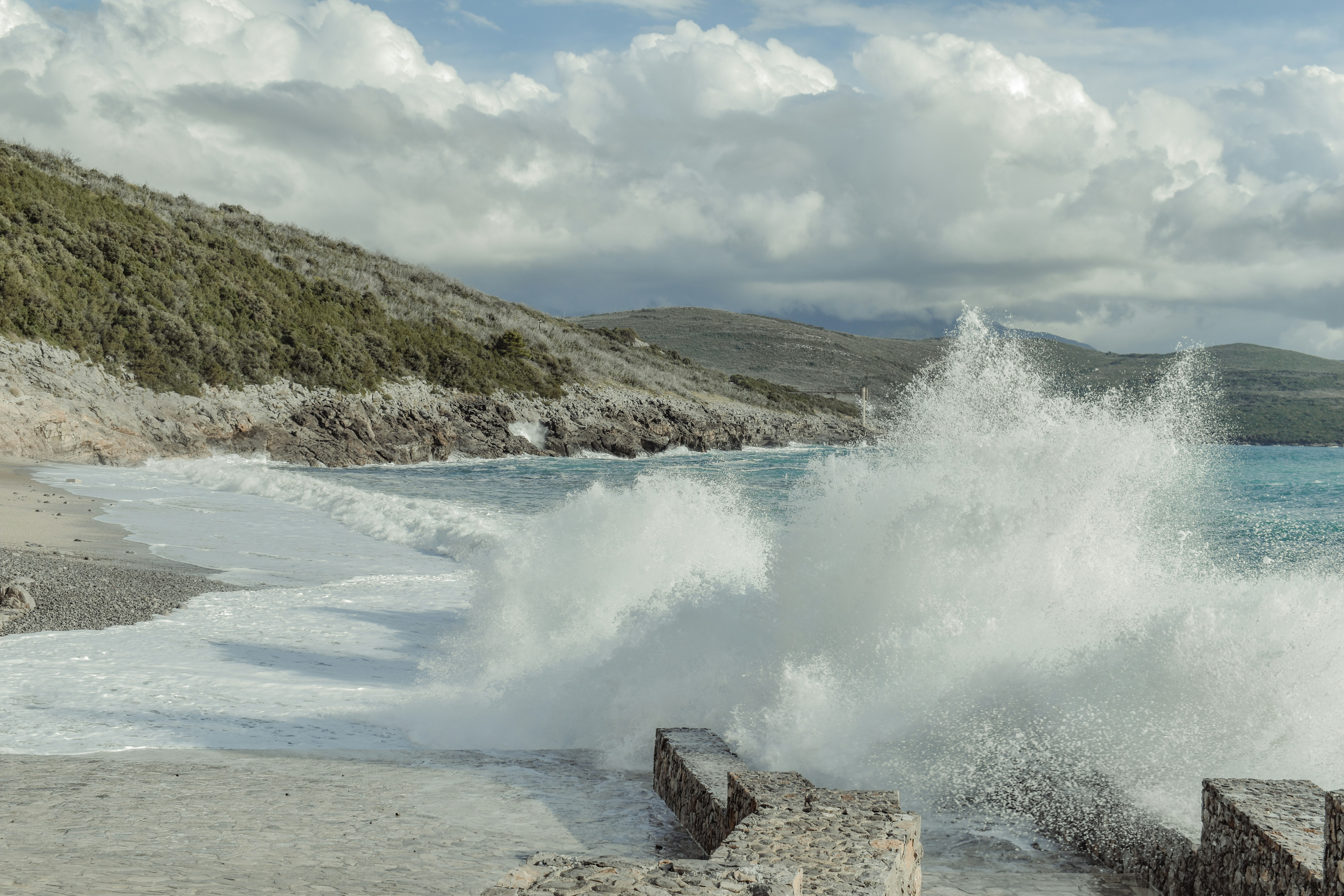 a large wave crashing onto the shore of a beach