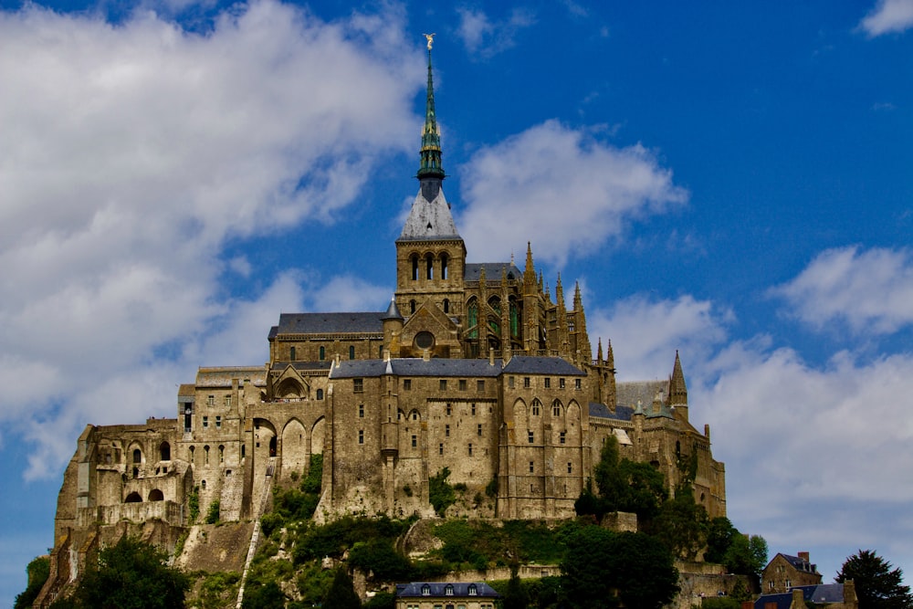 a castle with a steeple on top of a hill