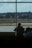 Traveler enjoying a serene moment by the window overlooking the airport runway