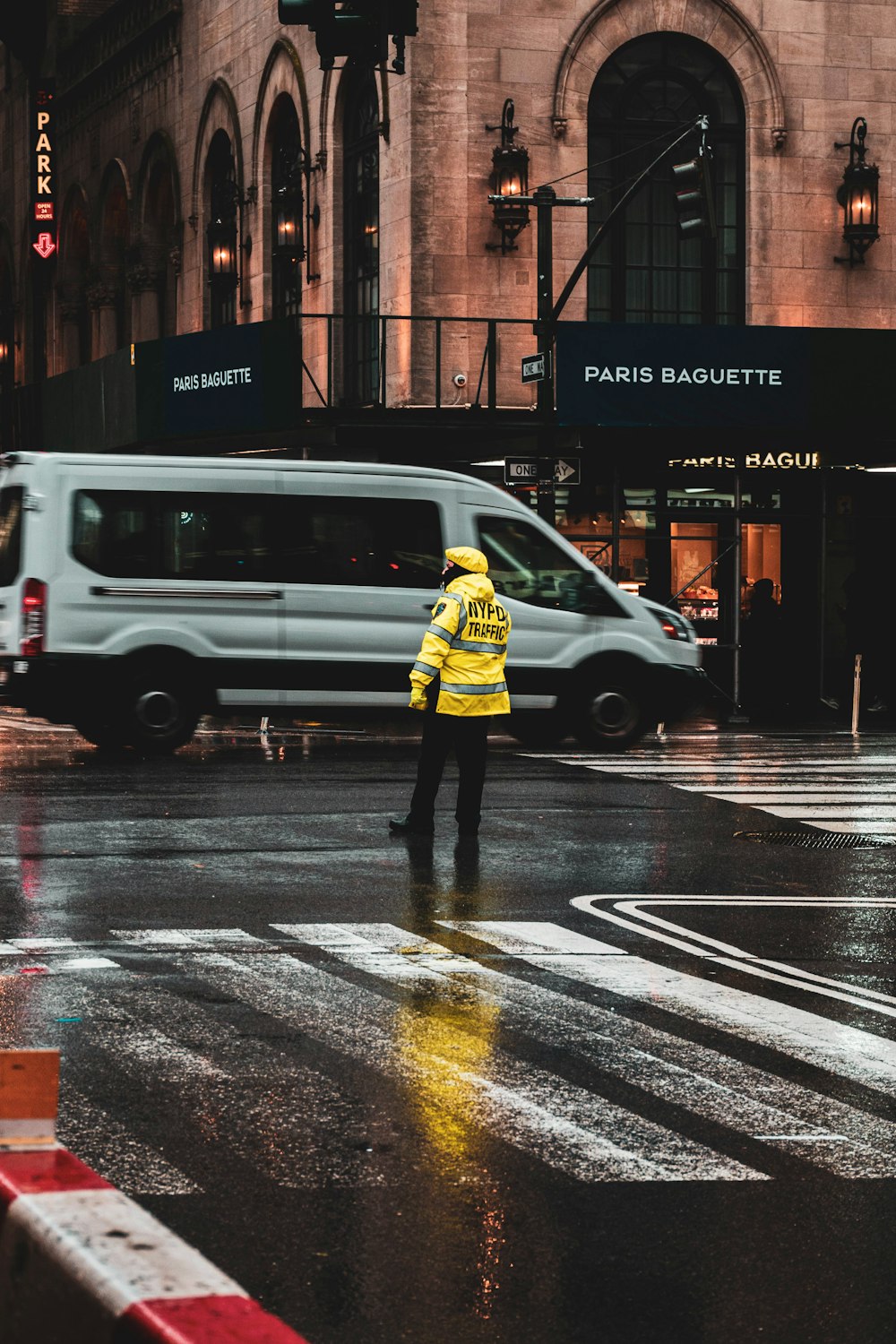 a man in a yellow jacket crossing the street