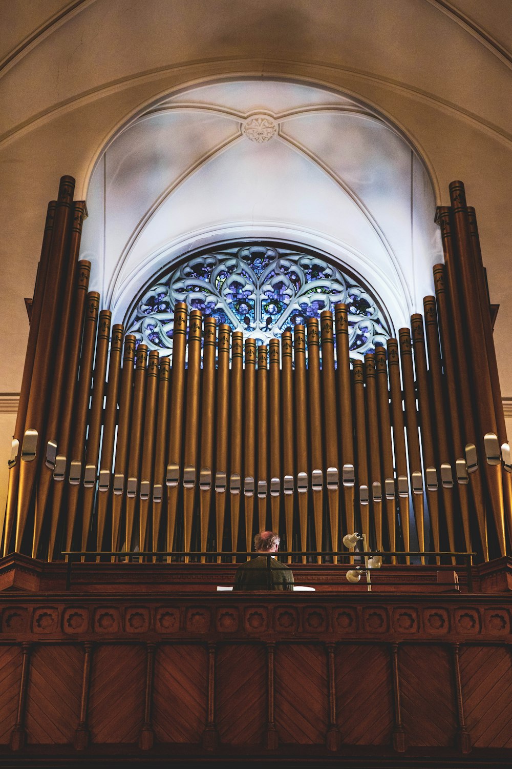a pipe organ in front of a stained glass window