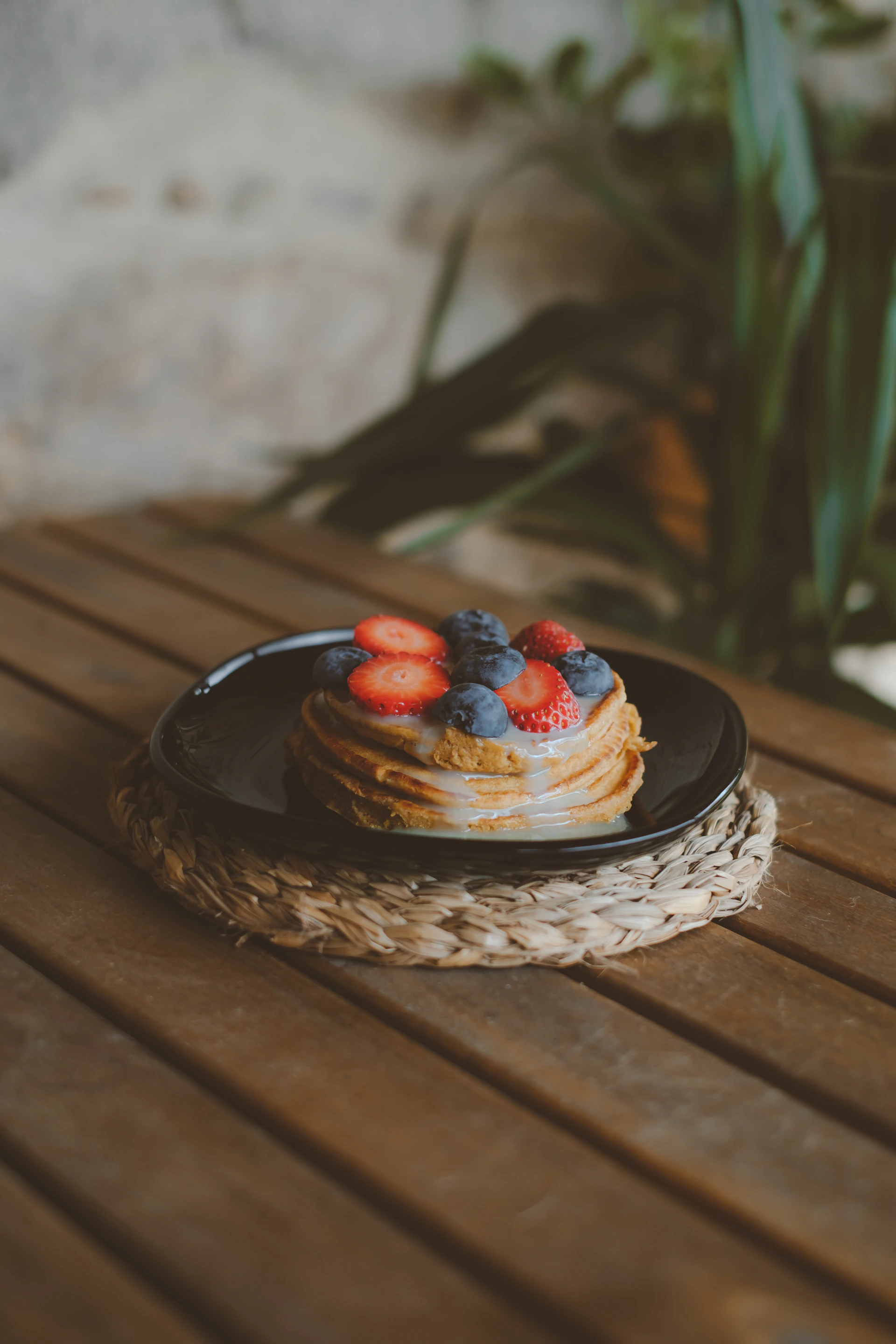 a stack of pancakes with strawberries and blueberries on a plate