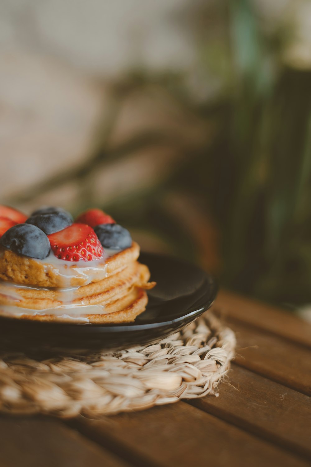 a stack of pancakes topped with fruit on a plate