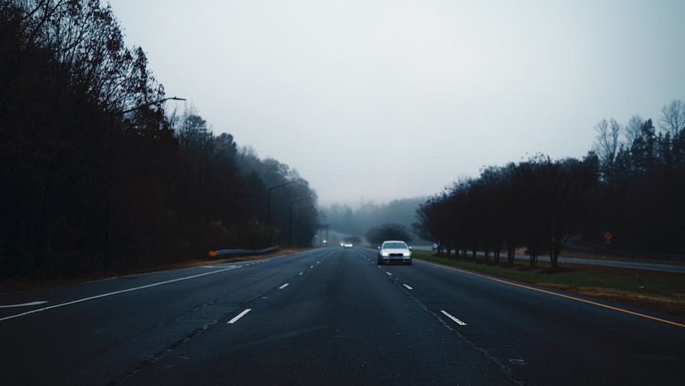 a car driving down a road in the fog