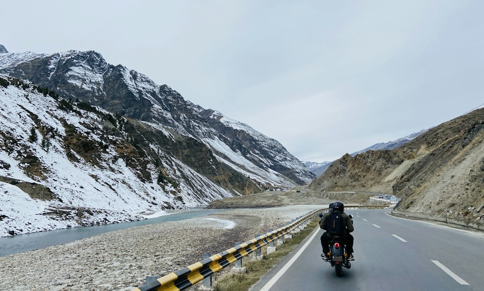 A motorcycle rider on a mountain road in Ladakh, India
