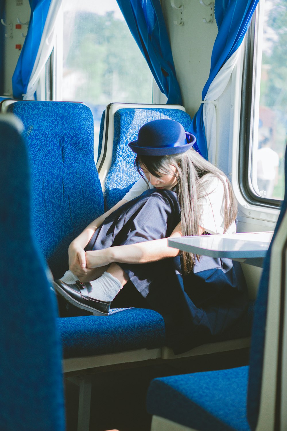 a woman sitting on a train reading a book