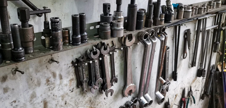 Wrenches and sockets hanging on a worn workshop wall