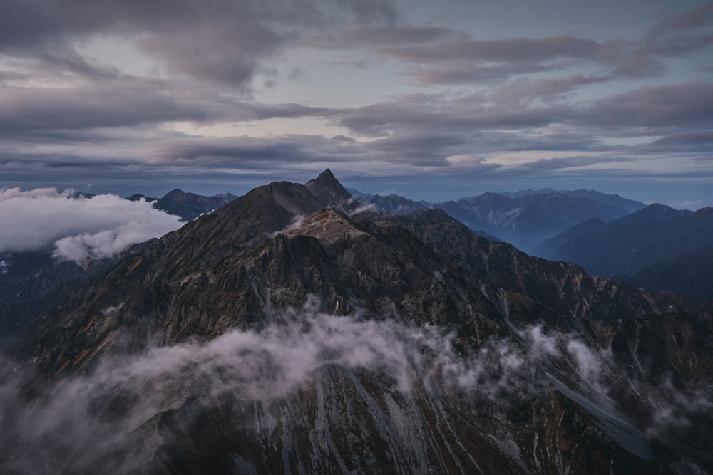 an aerial view of a mountain range with low clouds