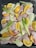 Raw chicken pieces are arranged on a baking tray, surrounded by cut fennel stalks and orange wedges. The colors of the ingredients are fresh and vibrant, with the oranges and fennel adding a contrasting brightness to the pink chicken.
