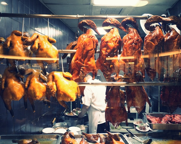 a man standing in front of a display of meat