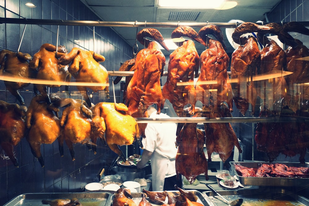 a man standing in front of a display of meat