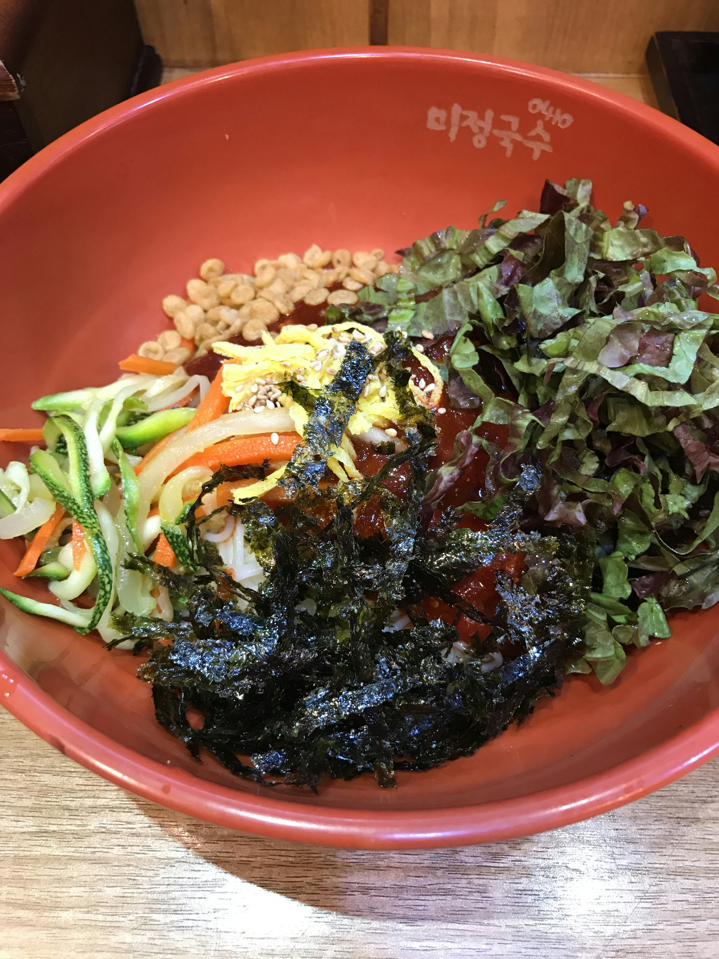 Colorful Korean bibimbap rice bowl with vegetables, egg, and gochujang sauce