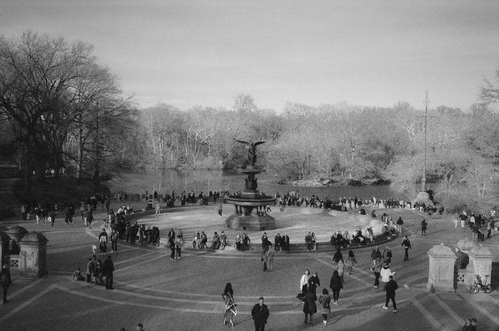 a crowd of people walking around a park