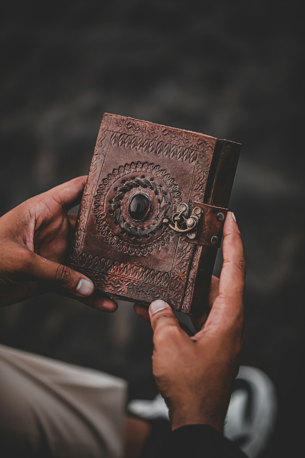 a person holding a brown book in their hands