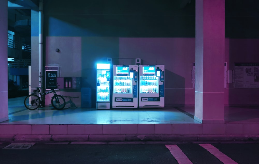 um par de máquinas de venda automática sentadas à beira de uma estrada